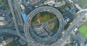 A photo of a round circle of highway exit ramps full of traffic seen from high above